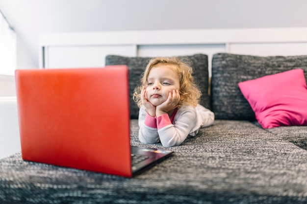 Fille s&#39;ennuie en regardant un film sur un ordinateur portable