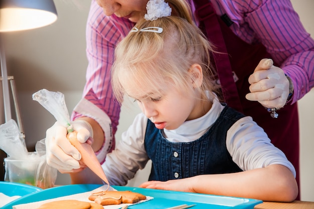 Fille et sa mère décoranting pain d'épice avec glaçage au sucre