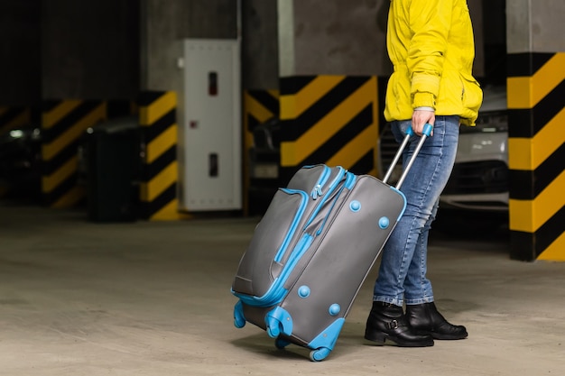 fille avec sac dans le parking de l'aéroport