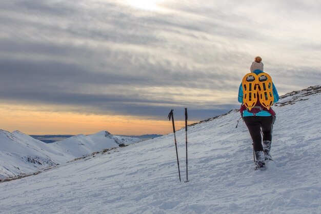 Fille avec sac à dos dans les montagnes de neige. Concept de style de vie