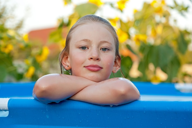 Fille se baigne dans une piscine bleue dans une maison de campagne