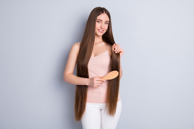 la fille se coiffe les cheveux avec la brosse à cheveux