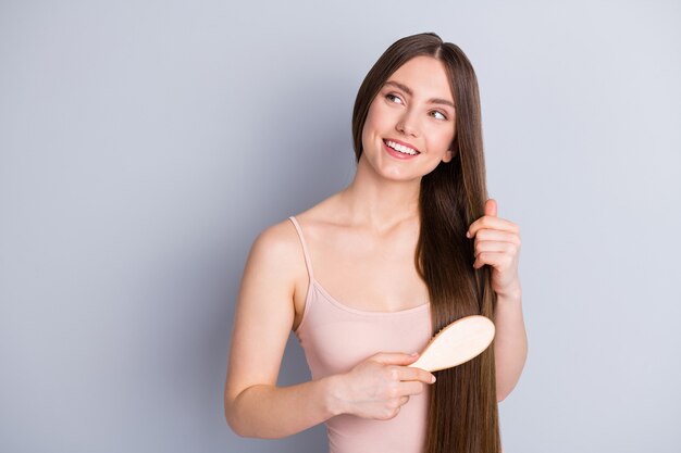 la fille se coiffe les cheveux avec la brosse à cheveux