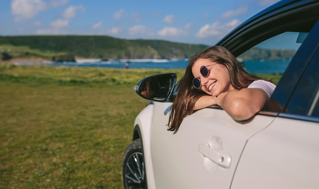 Fille se penchant sur la fenêtre de la voiture