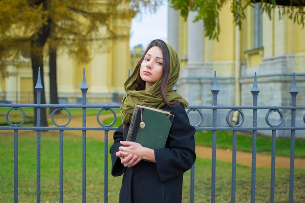 La fille se promène dans le parc avec un livre