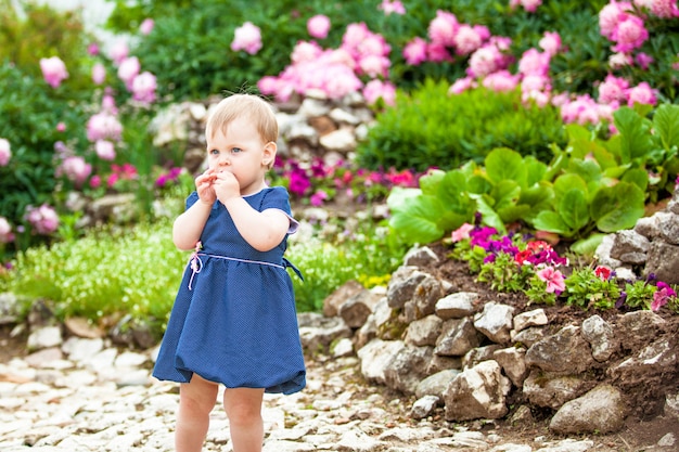 Fille se promène dans le parc avec des parterres de fleurs