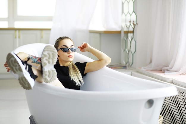 La fille se repose dans le grenier Jeune fille élégante posant dans la salle de bain