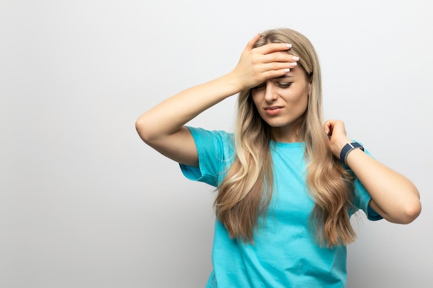 Fille se tenant à un mal de tête sur un fond blanc