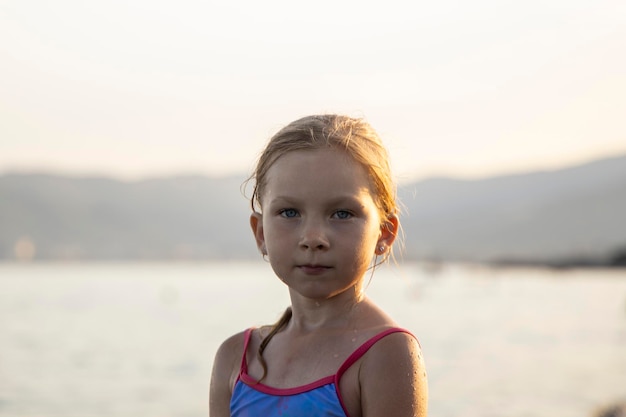 Photo la fille se tient sur le rivage et la plage