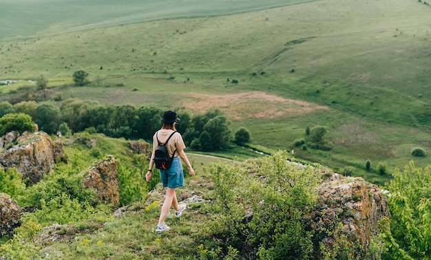 la fille se tient sur un rocher à l'arrière-plan d'un beau paysage ukrainien et profite de la vue