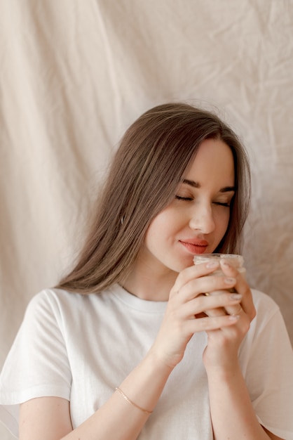 Fille sent le cosmétique du visage