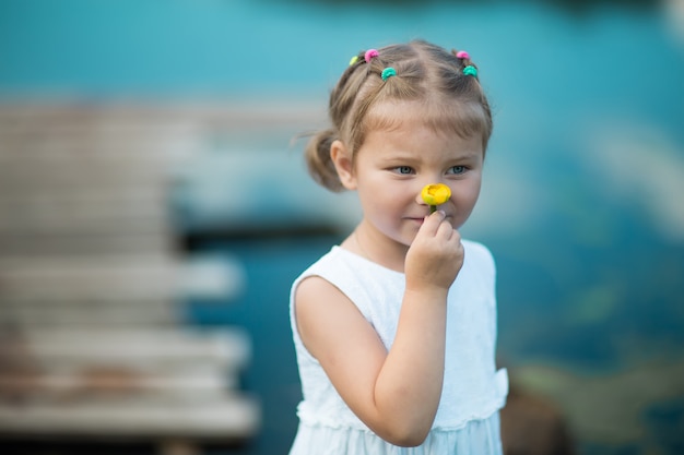 Fille sentant une fleur