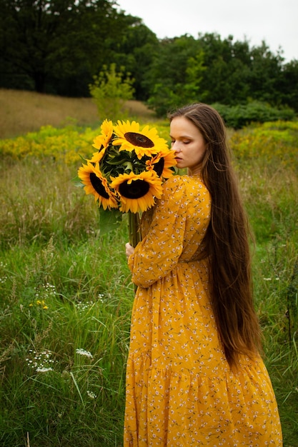 Fille sentant un tournesol dans un champ