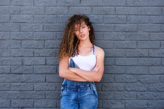 Fille sérieuse debout avec les bras croisés et l&#39;attitude