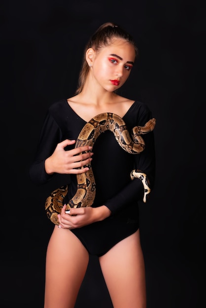 Fille avec un serpent sur son corps sur fond noir