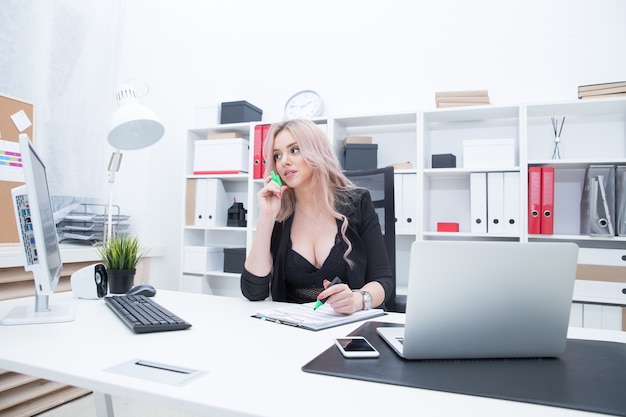 Fille sexy sur le lieu de travail à l'ordinateur