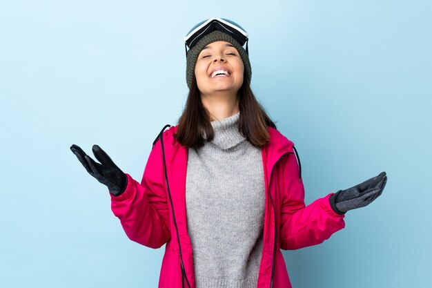 Photo fille de skieur de course avec des lunettes de snowboard souriant beaucoup