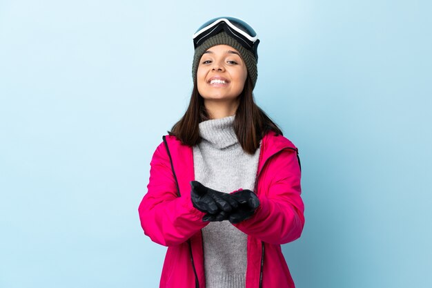 Fille de skieur de race mixte avec des lunettes de snowboard