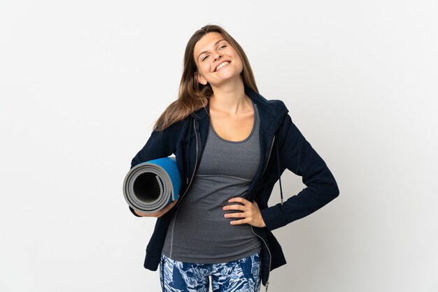 Fille slovaque allant à des cours de yoga isolé sur fond blanc posant avec les bras à la hanche et souriant