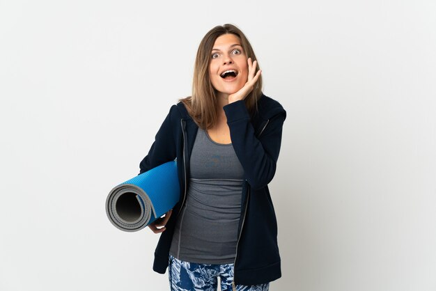 Fille slovaque allant à des cours de yoga isolés sur fond blanc avec une expression faciale surprise et choquée