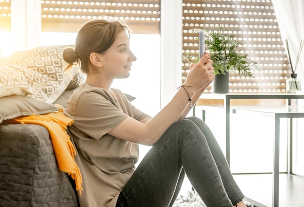 Fille avec smartphone à la maison