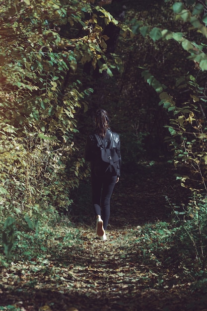 Fille solitaire marchant dans la forêt d'automne. , vue arrière