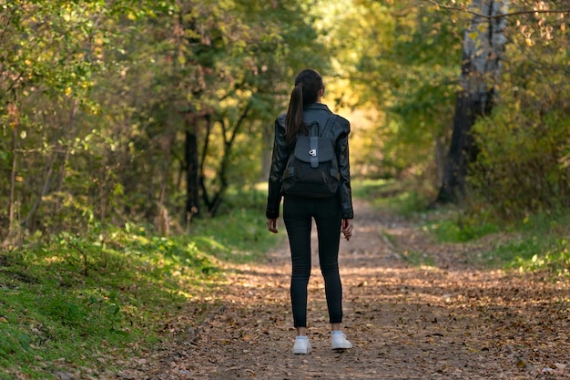 Fille solitaire se tient dans le parc et lève les yeux