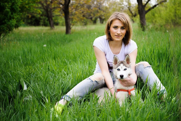 Une fille et son chien husky marchant dans un parc