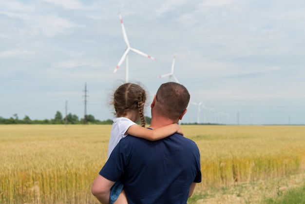 Une fille et son père regardent l'éolienne sur le terrain. Écologie. Avenir.