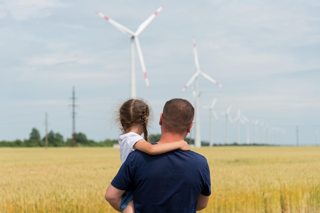 Une fille et son père regardent l'éolienne sur le terrain Ecology Future