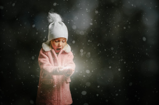 Fille soufflant dans la neige sur