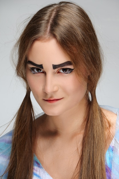 Fille avec des sourcils broussailleux et des nattes