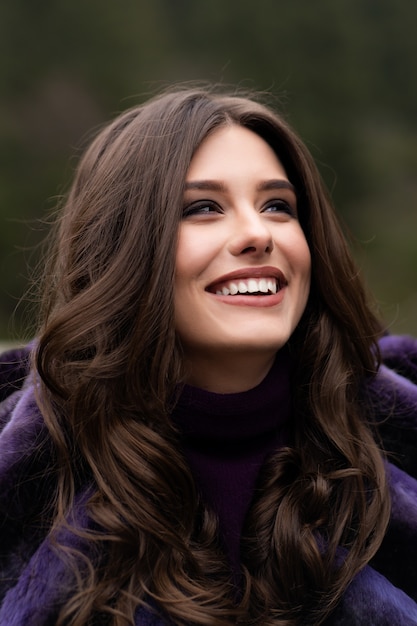 Fille souriant à la caméra sur les bois d'hiver