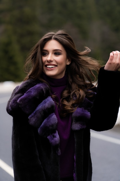 Fille souriant à la caméra sur les bois d'hiver