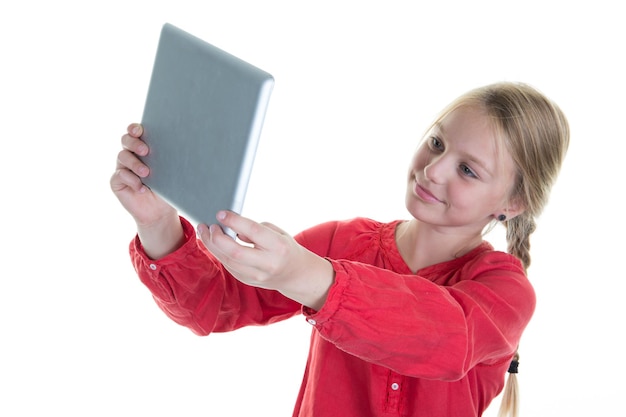 Fille souriant joyeusement, faisant une photo de selfie avec tablette. Fille 8-10 ans