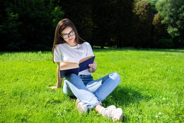 Une fille souriante aime lire un livre