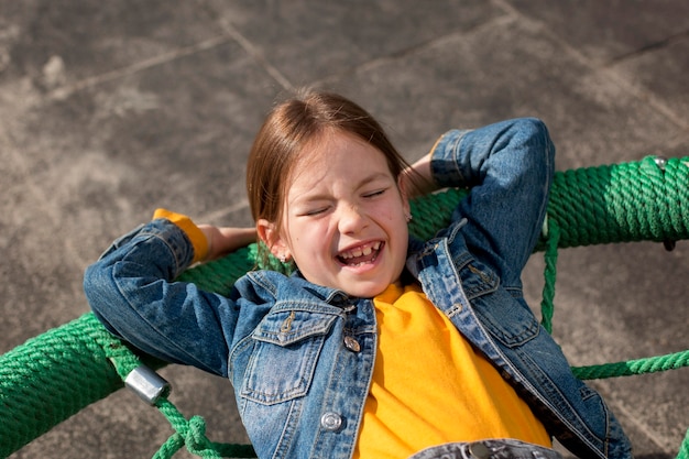 Fille souriante de coup moyen portant à l'extérieur