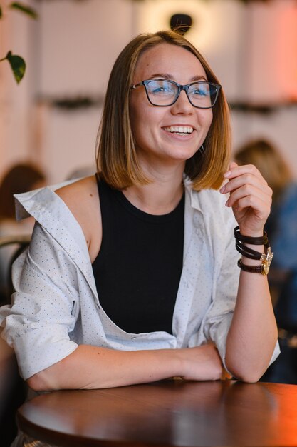 Fille souriante dans des verres noirs.