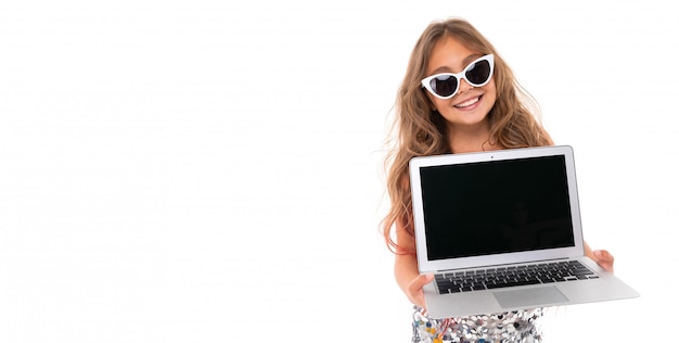 fille souriante heureuse en lunettes de soleil blanches tenant un ordinateur portable moderne avec écran noir