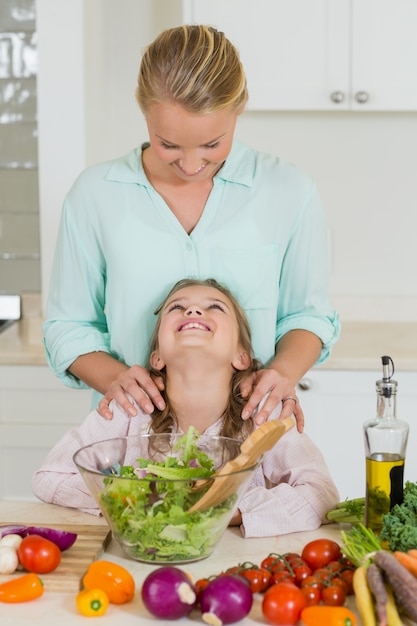 Fille souriante interagissant avec la mère dans la cuisine