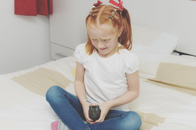 Photo une fille souriante avec un jouet assise sur le canapé à la maison