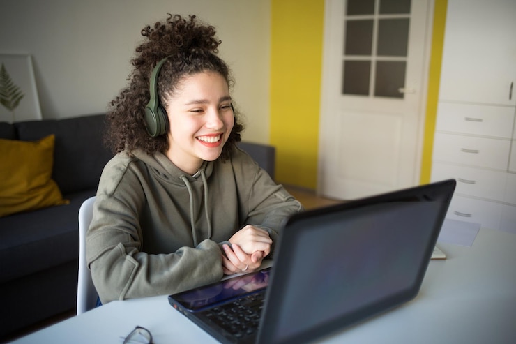 Photo une fille souriante portant des écouteurs qui parle en vidéo à la maison.