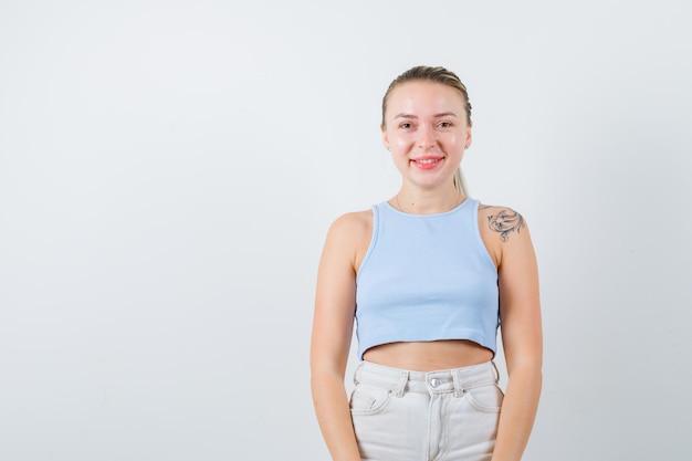 fille souriante pose à la caméra sur fond blanc