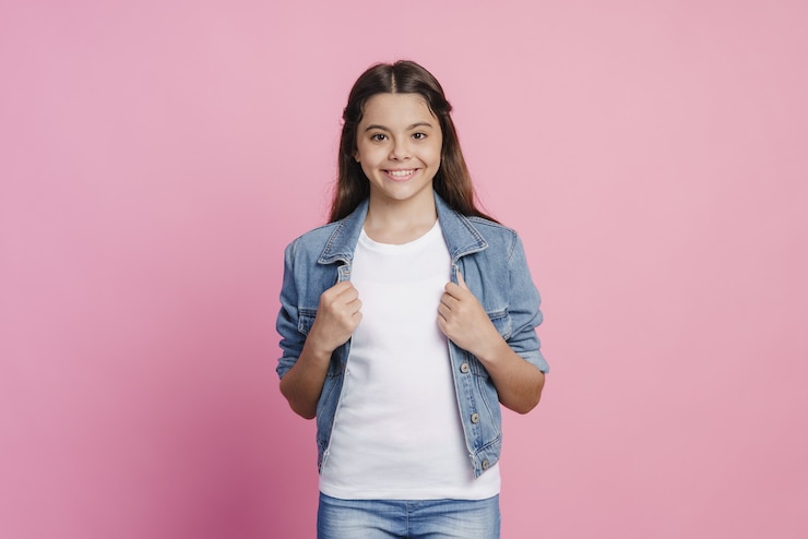 Photo fille souriante et positive posant sur fond rose. belle adolescente
