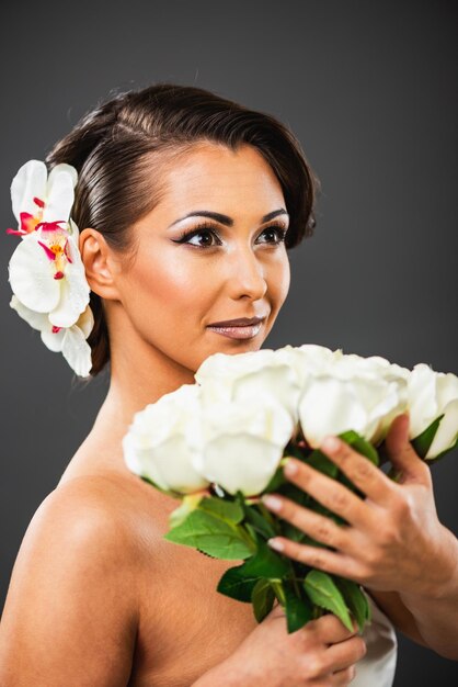 Photo la fille souriante avec les roses blanches