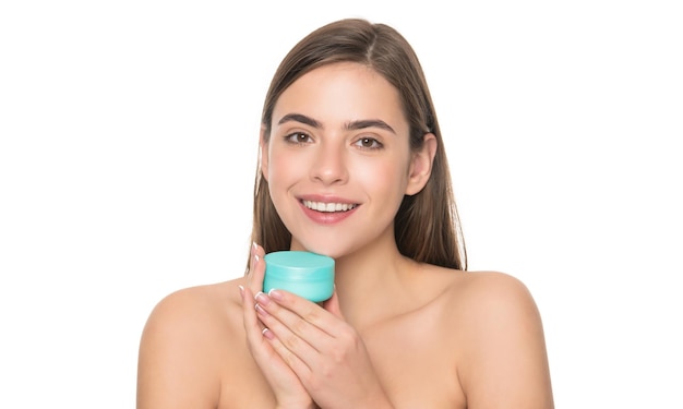 Une fille souriante tient un masque capillaire avec une crème pour la peau, une habitude quotidienne et des soins personnels