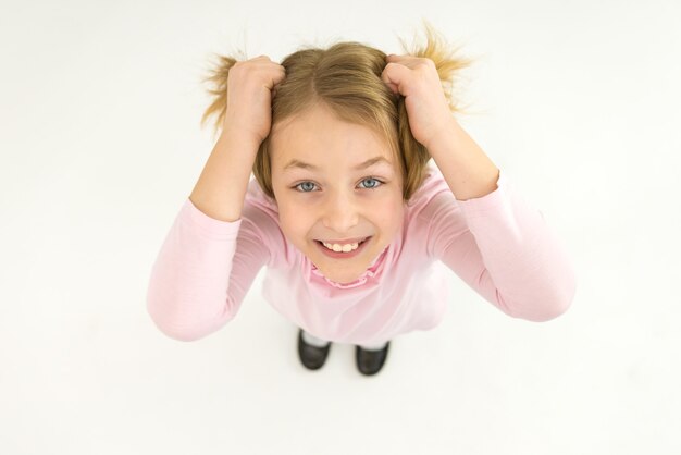 La fille souriante tient ses cheveux. Vue d'en-haut