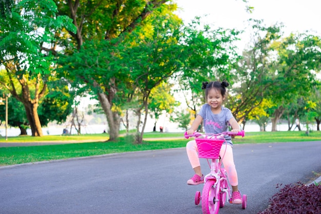 Une fille souriante à vélo dans la rue.