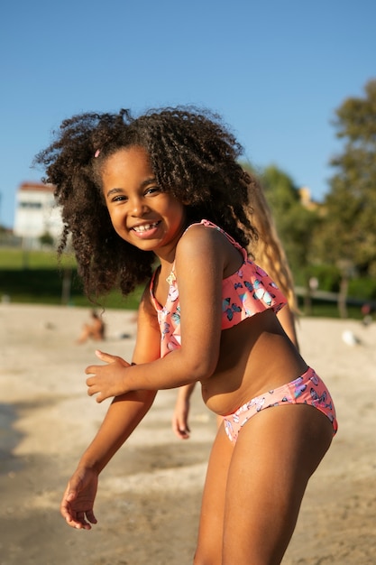 Photo fille souriante vue de côté à la plage