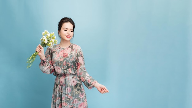 La fille sourit avec un bouquet de fleurs